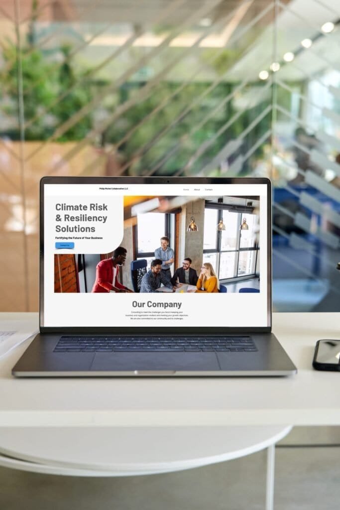 Laptop screen featuring Phil Michele's website in a stylish office setup with blurred glass background.